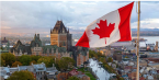 Canadian flag waving in foreground of city