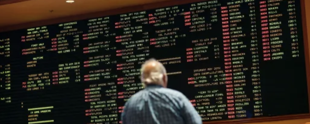Game lines posted with man standing in front of board