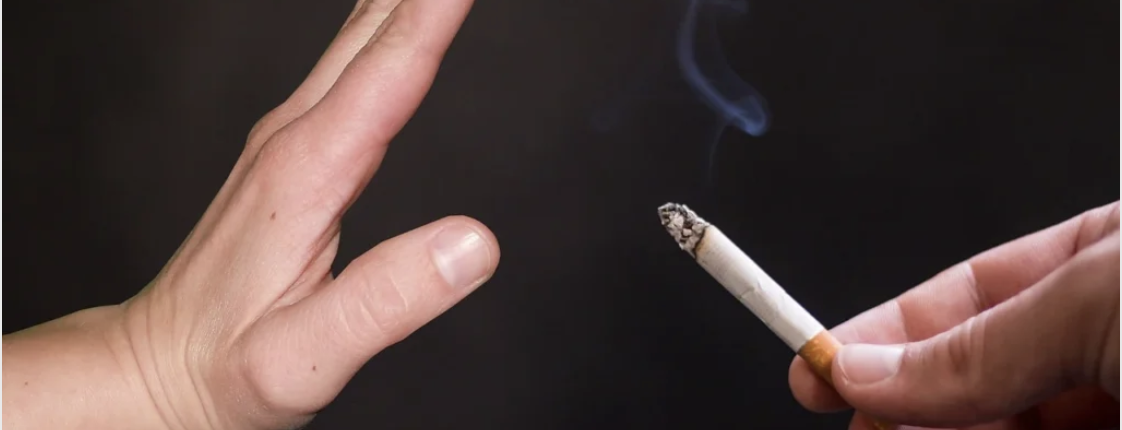 No smoking as hand waves off cigarette