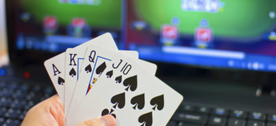 Poker cards in front of laptop with online poker site