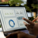 Analyst reviewing centralized player data dashboard on laptop with multiple metrics