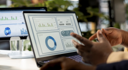 Analyst reviewing centralized player data dashboard on laptop with multiple metrics