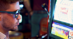 Man with sunglasses playing on a casino machine