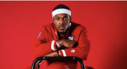 Ryan Conwell before a red background leaning on ball